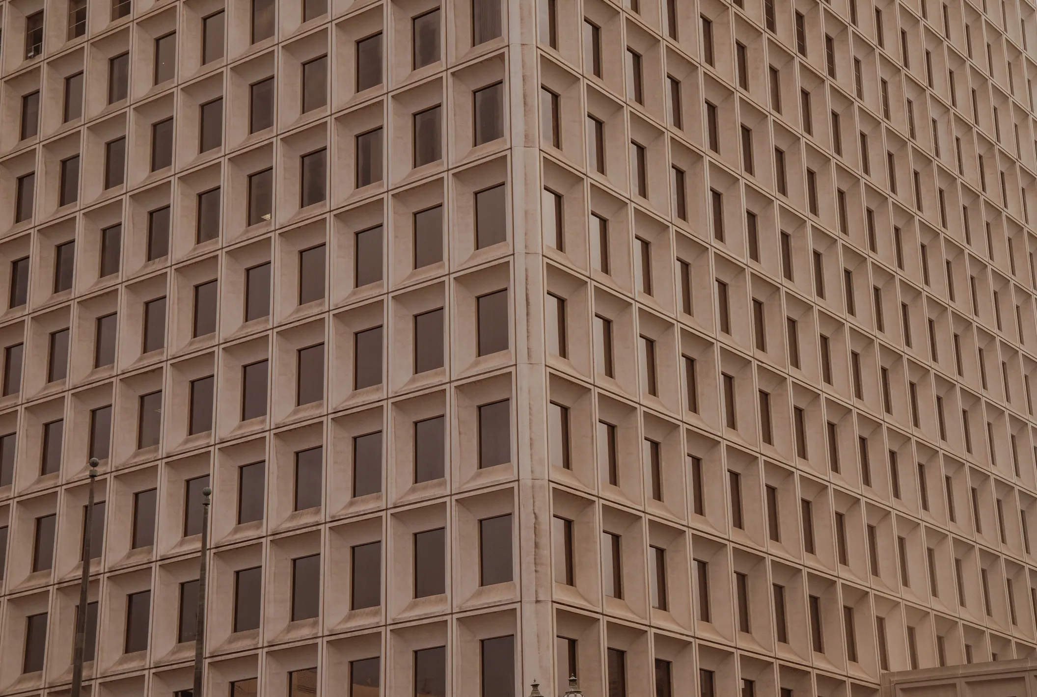 Tall building with many windows and a clock tower in the background