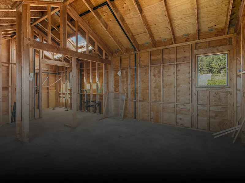 Room with a lot of wood framing and a window, with a few wooden poles