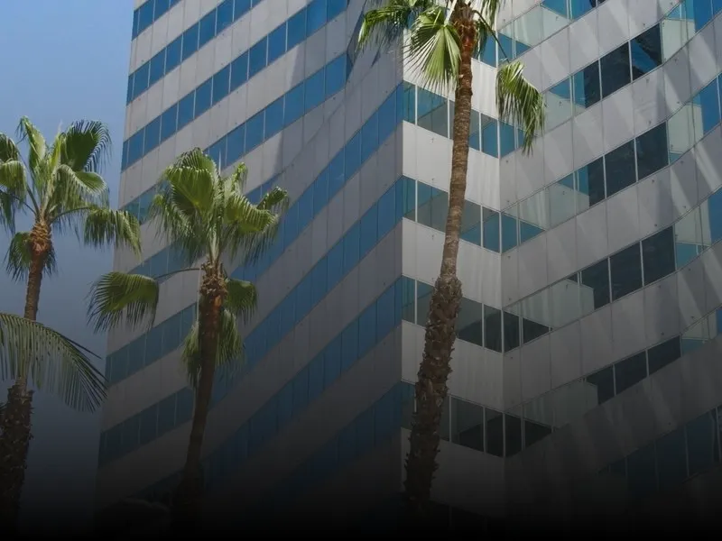 Modern office tower with tropical trees